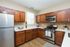 Open concept modern kitchen with quartz countertops and stainless steel appliances
