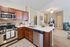 Open concept modern kitchen and dining area with quartz countertops and stainless steel appliances