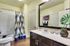Designer bathroom with luxury tub/shower combo, Premium quartz countertops, faux wood flooring. Custom framed mirror.