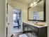 Designer bathroom with luxury tub/shower combo, Premium quartz countertops, faux wood flooring. Custom framed mirror.