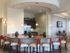 A series of chairs arranged around a built-in kitchen island with refrigerator and kitchen area l Monterey Pointe