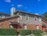 Exterior red brick with gray paneling and green landscaping