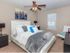 Elegant Master Bedroom with ceiling fan and plush carpet