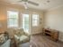 Furnished sitting area with ceiling fan in resident lounge facing back porch