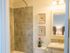 Bathroom with shower tub, toilet, sink with cabinet, mirror and lighting