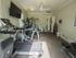 Fitness Center with Treadmill, Elliptical, Universal Weight Machine, Free Weights, ceiling fan, and television