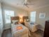 Bedroom with two twin beds, night stand, dresser, ceiling fan, and two windows