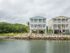 Exterior of apartment building behind green space surrounding community and water-front community