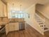 Kitchen with sink, stainless steel oven and dishwasher next to stairs