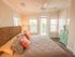 Bedroom with bed, nightstand, and dresser with ceiling fan and balcony door