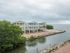 Aerial view of exterior of apartment building with private beach on water