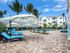 Swimming pool deck with adjustable deck umbrellas covering blue lounge chairs l High Ridge Landing