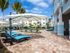 Several lounge chairs with deck umbrellas arranged around swimming pool l High Ridge Landing