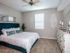 Bedroom with ceiling fan, bed, and large chest-of-drawers l High Ridge Landing