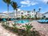 Swimming pool surrounded by landscaping and blue lounge sundeck chairs l High Ridge Landing