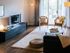 The Henry Apartments, interior, living room, sofa, area rug, wood floor, sliding glass doors, tv, game on coffee table