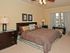 Mirasol at Celebration, interior, bedroom, carpet, large bed, dark furniture, large windows, ceiling fan