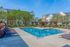 Townhomes for Rent in Woodbury MN - Woodbury Park at City Centre - Sparkling Pool with Lounge Chairs, Gazebo with Patio Furniture and a Fire Pit,. Surrounded by Grass and Trees.