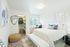 Inviting bedroom with a plush bed, tasteful decor, and natural light from a large window.
