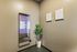 Contemporary apartment entrance with a smart mirror, decorative plant, and minimalist wall art.