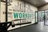Modern gym interior with motivational wall art and exercise equipment.