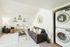 Bright living room with a comfortable sofa, wall-mounted shelves, and a convenient in-unit laundry.