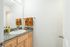 Chic bathroom featuring a granite countertop, modern sink, and warm-toned towels.