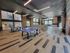 Vibrant community recreation room with modern lighting, cozy seating areas, and a stylish ping pong setup on sleek hardwood floors.