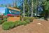 Inviting entrance to The Radley Student Living with vibrant signage surrounded by lush greenery and mature trees, creating a welcoming atmosphere.