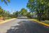 Inviting entrance to a serene apartment community, featuring well-maintained landscaping and secure gated access.