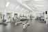 Spacious and well-equipped apartment gym featuring modern fitness equipment, bright natural lighting, and sleek design.