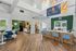 Bright and welcoming leasing office with modern design, featuring stylish seating, a wooden reception desk, and vibrant greenery accents.