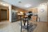 Charming open-concept kitchen with modern stainless steel appliances, wooden cabinetry, and cozy dining area in a bright and inviting space.