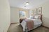 Inviting bedroom with plush bedding, soft lighting, and wall art, exuding warmth and comfort.