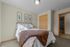 Cozy bedroom with elegant decor, featuring a plush bed with soft linens and stylish artwork on the wall.