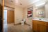 Spacious and inviting bathroom with modern fixtures, stylish wall decor, and ample storage space in a cozy apartment.