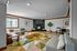 Chic living room with modern decor, featuring a vibrant geometric rug, cozy seating, and a warm fireplace.