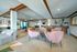 Inviting communal lounge with plush pink chairs, modern decor, and vibrant wooden accents, ideal for socializing.