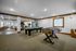 Spacious game room with a pool table and foosball table, open seating area, and cozy fireplace setup, perfect for relaxation and entertainment.