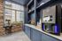 Modern apartment amenities featuring a stylish coffee and beverage station with a state-of-the-art coffee machine and a charming popcorn cart, set against a sleek stone accent wall.
