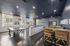 Inviting communal lounge with sleek interiors, featuring a modern bar, cozy seating, and a ping pong table under elegant lighting.