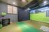 Indoor golf simulation room with high-tech equipment and immersive green fairway projection, perfect for year-round practice.