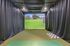 Luxurious indoor golf simulator with vibrant green course projection, perfect for at-home leisure and entertainment.