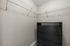Spacious walk-in closet with sleek black dresser and ample shelving, perfect for organized storage.