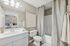 Inviting bathroom with modern fixtures, elegant white vanity, and a soothing neutral palette, offering a glimpse into a cozy bedroom with stylish decor.