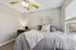 Cozy bedroom featuring a plush bed with fluffy pillows, a tranquil workspace with a desk, and warm natural lighting from a large window.
