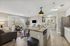 Bright open-concept living space with modern kitchen, cozy seating area, and sliding glass doors leading to a balcony view.