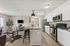 Modern open-concept living space with a sleek kitchen island, stainless steel appliances, and stylish decor.
