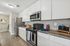 Modern kitchen with sleek stainless steel appliances, stylish countertops, and ample white cabinetry for storage.