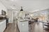 Modern open-concept living area with sleek kitchen, cozy lounge space, and large sliding doors to a scenic balcony.